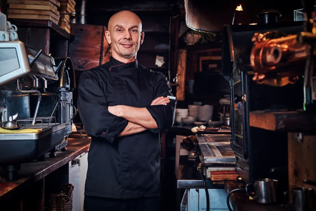 Chef restaurateur bras croisés dans la cuisine de son restaurant à Montpellier