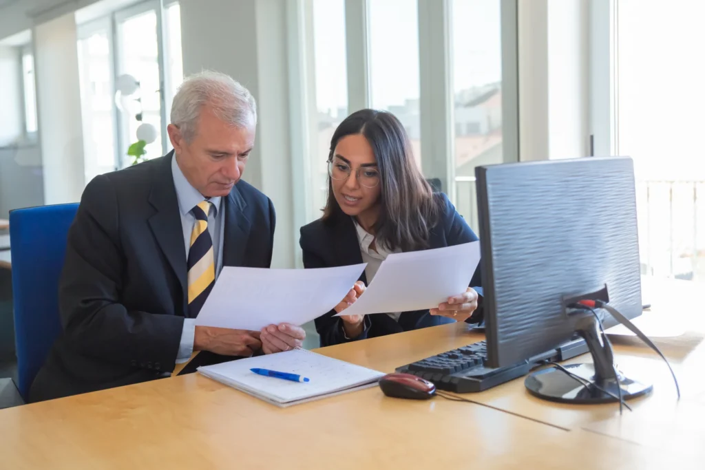 Expert-comptable expliquant un document financier à un dirigeant lors d'un rendez-vous conseil